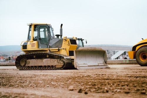 Yellow bulldozer on dirt at construction site.